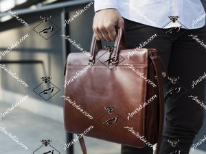 کیف چرم اداری قهوه ای تیره در دست مرد